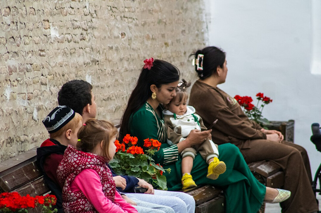 Community members sitting together on a bench talking